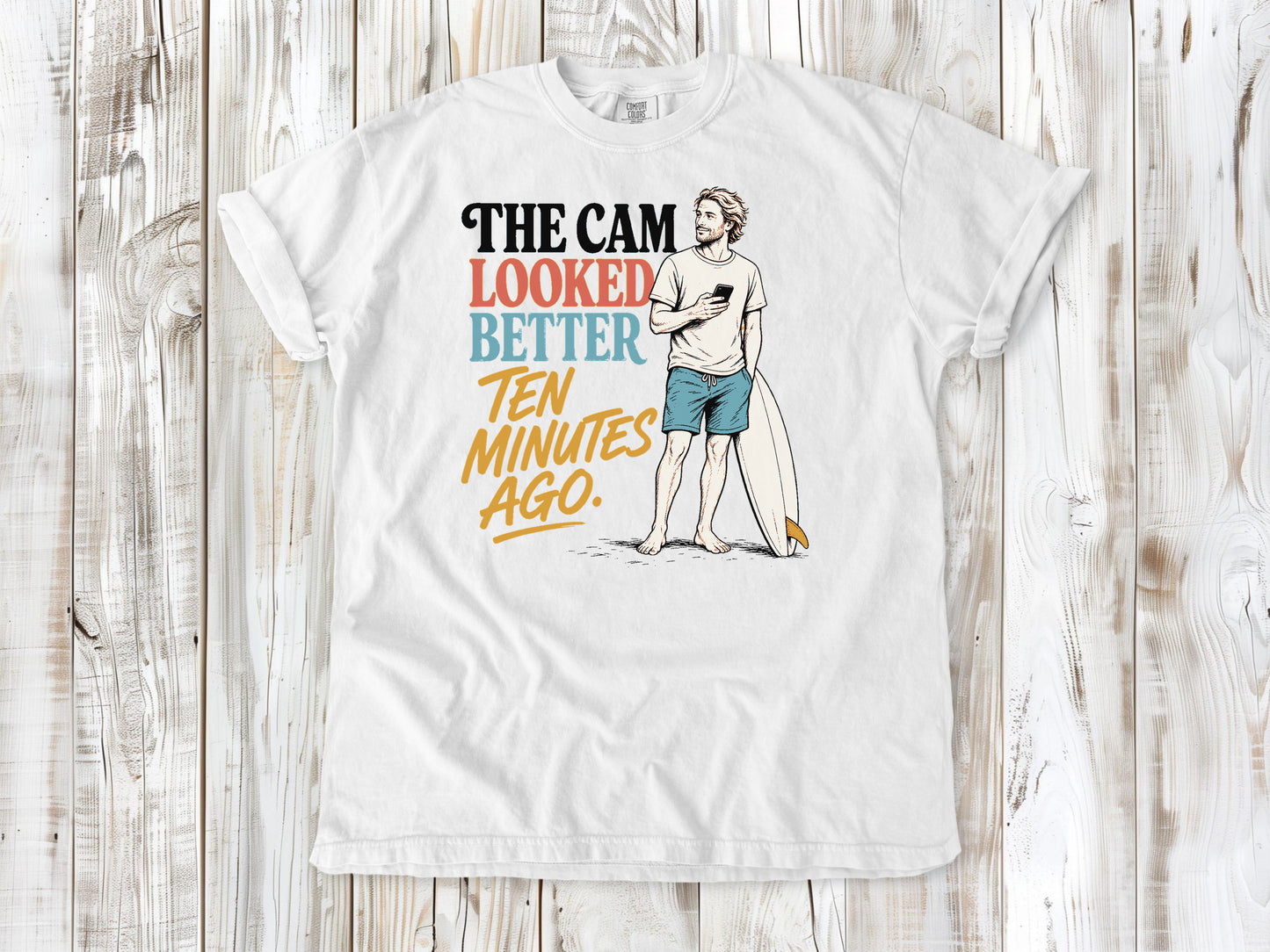 White garment-dyed tee with The Cam Looked Better Ten Minutes Ago surfer graphic.