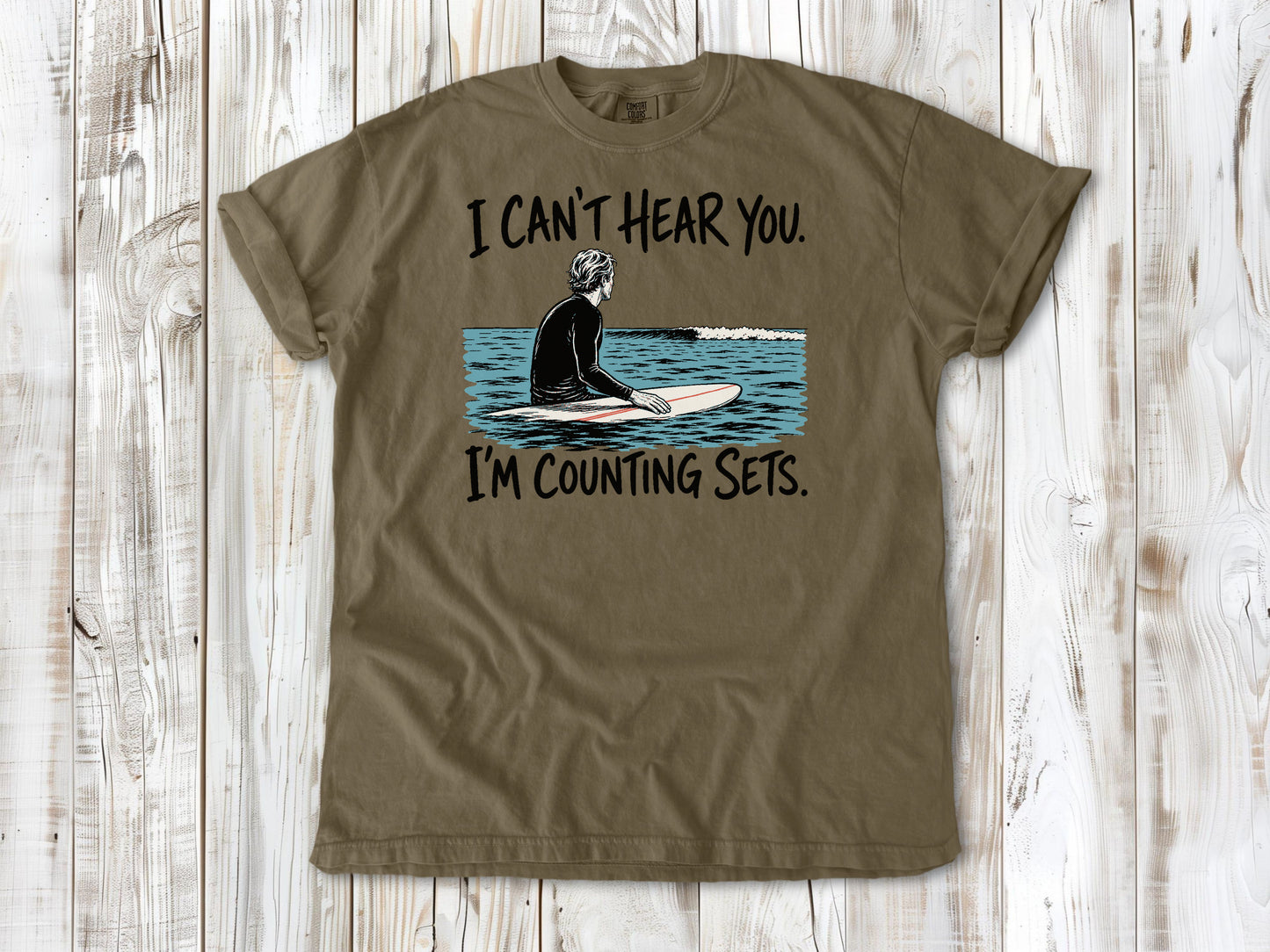 Graphite garment-dyed tee with I Can't Hear You I'm Counting Sets surfer graphic.