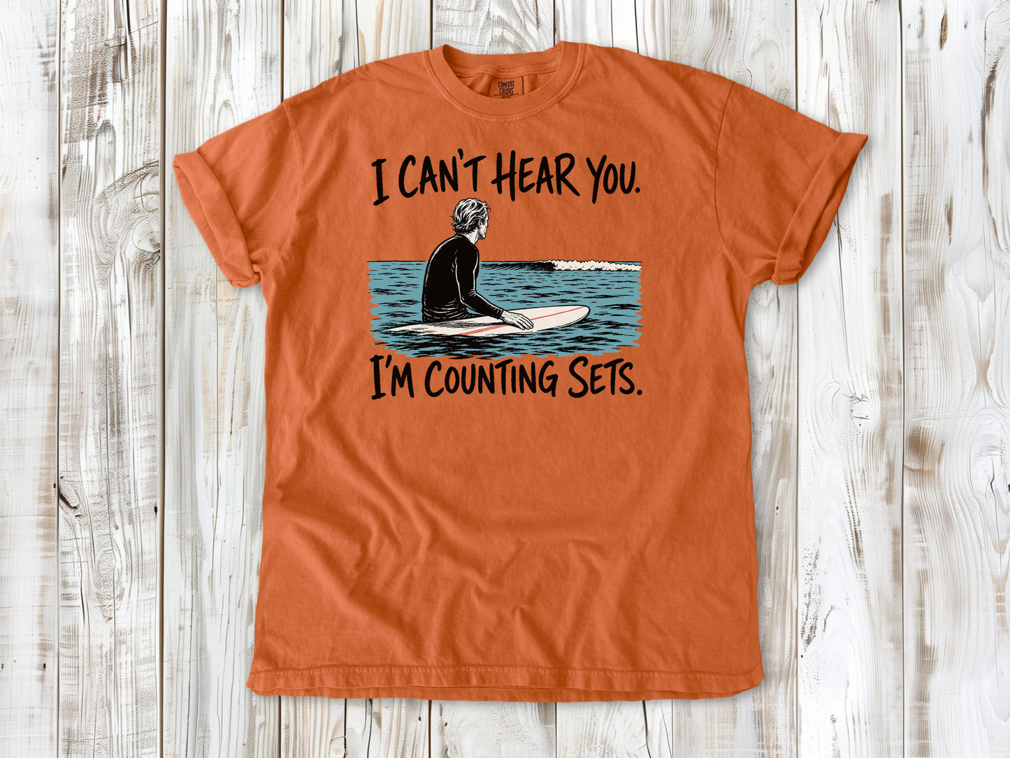 Seafoam garment-dyed tee with I Can't Hear You I'm Counting Sets surfer graphic.