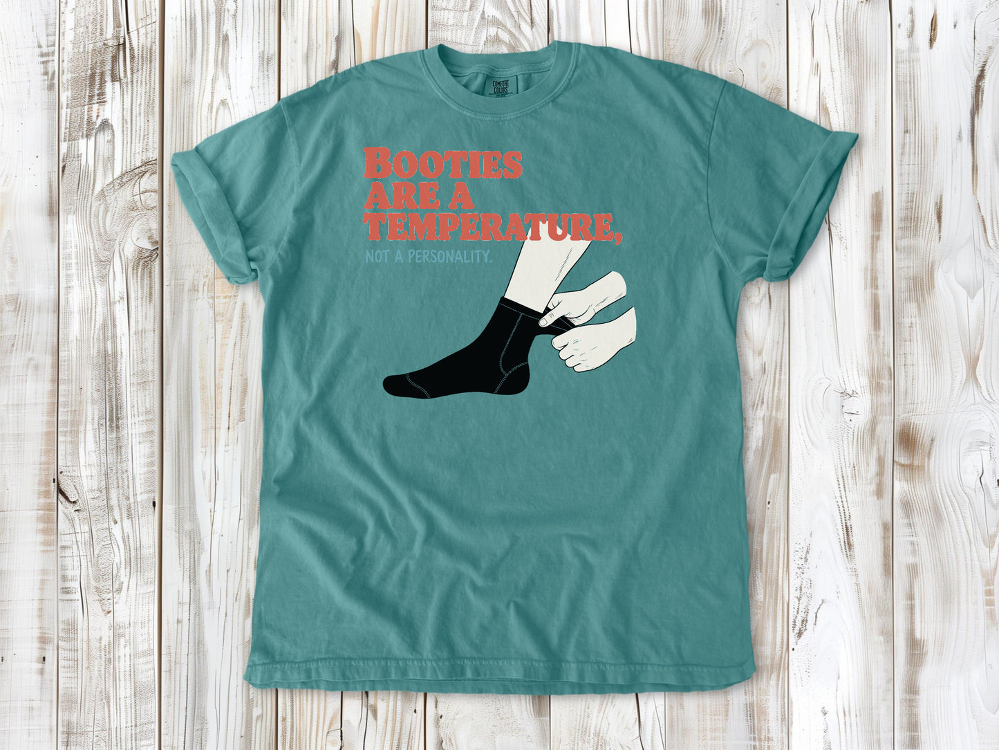 Mustard garment-dyed tee with Booties Are a Temperature Not a Personality cold water surfing graphic.