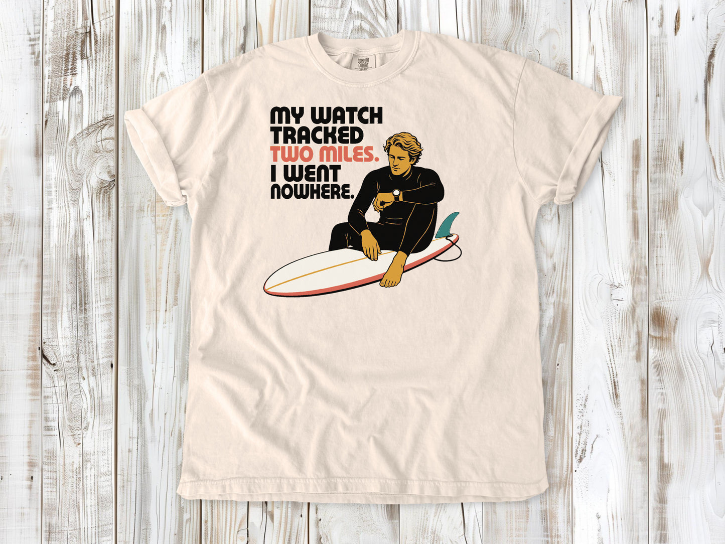 Butter garment-dyed tee with My Watch Tracked Two Miles I Went Nowhere surfer graphic.