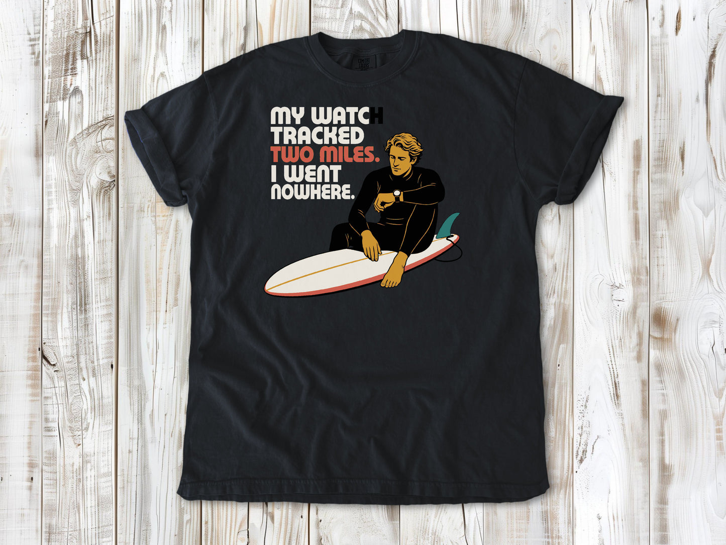 Washed Denim garment-dyed tee with My Watch Tracked Two Miles I Went Nowhere surfer graphic.