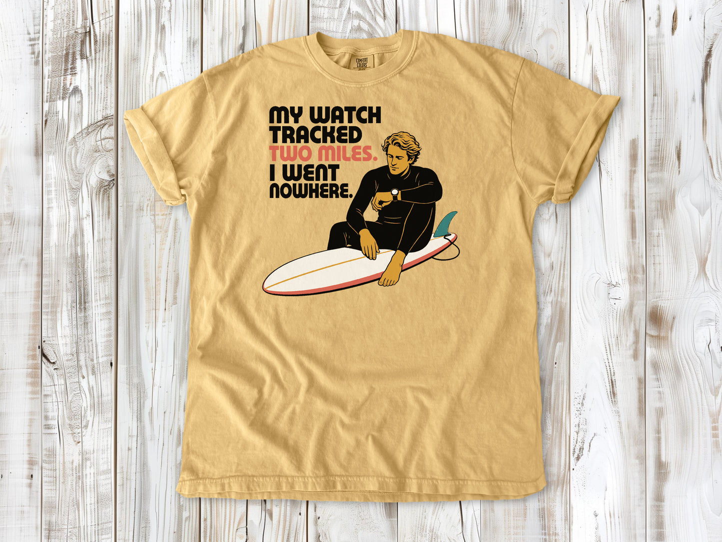 Burnt Orange garment-dyed tee with My Watch Tracked Two Miles I Went Nowhere surfer graphic.