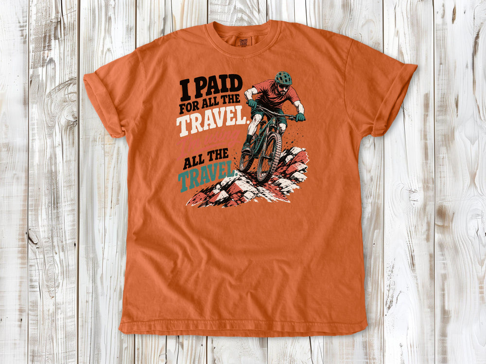 Seafoam garment-dyed tee with I Paid for All the Travel mountain bike graphic.