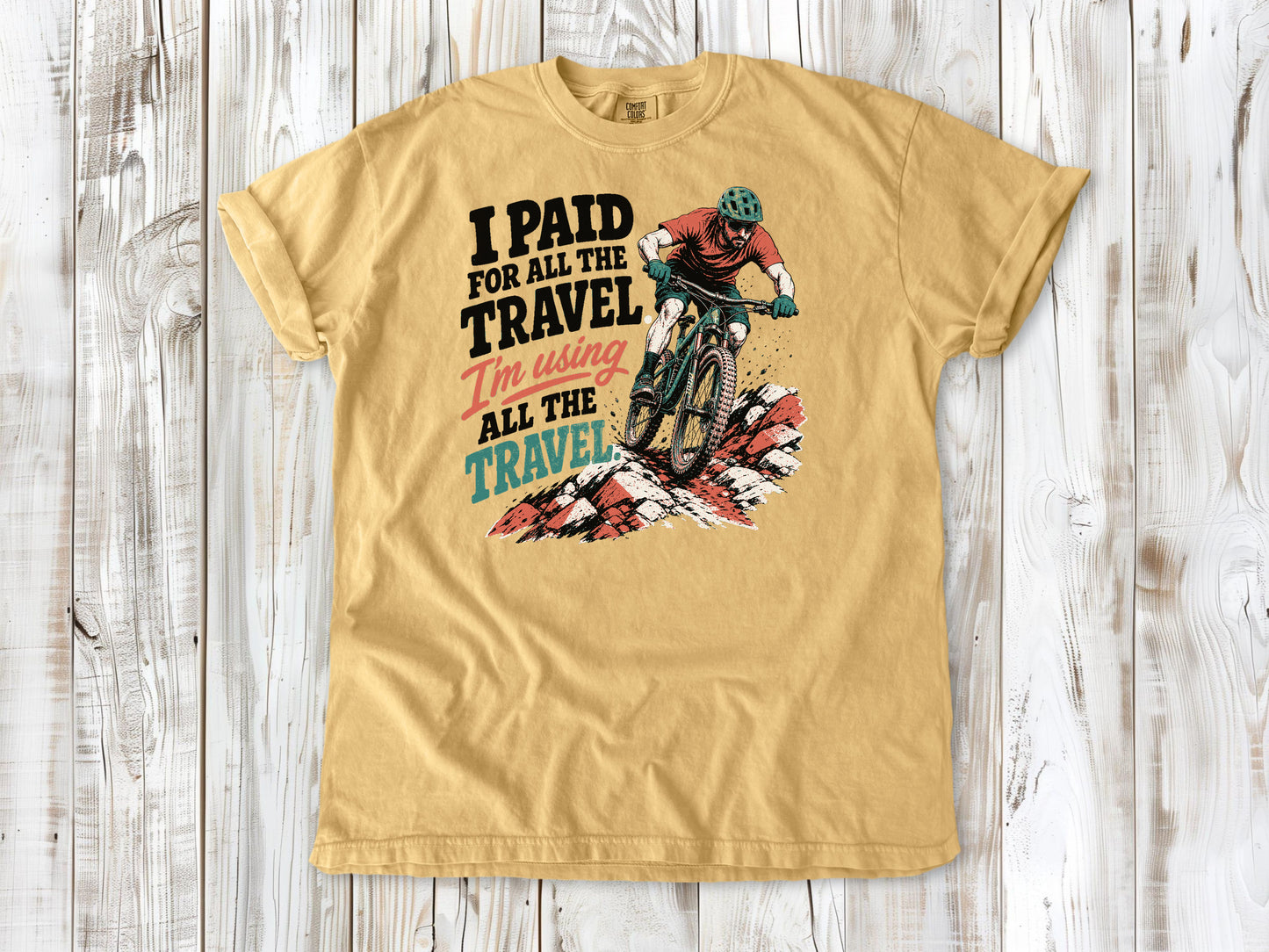 Burnt Orange garment-dyed tee with I Paid for All the Travel mountain bike graphic.