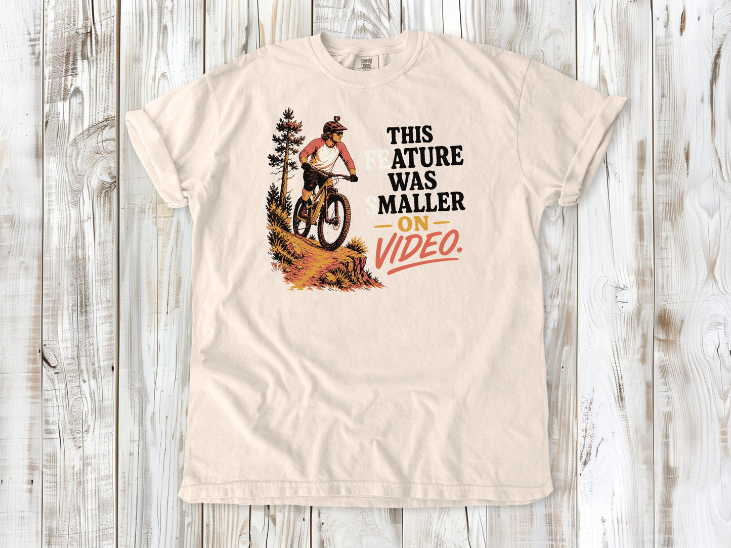 Butter garment-dyed tee with This Feature Was Smaller on Video mountain bike trail graphic.