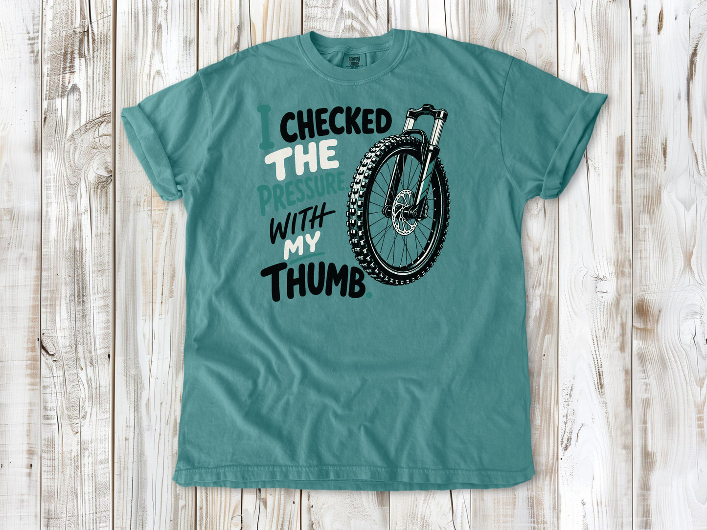 Mustard garment-dyed tee with I Checked the Pressure With My Thumb mountain bike tire graphic.