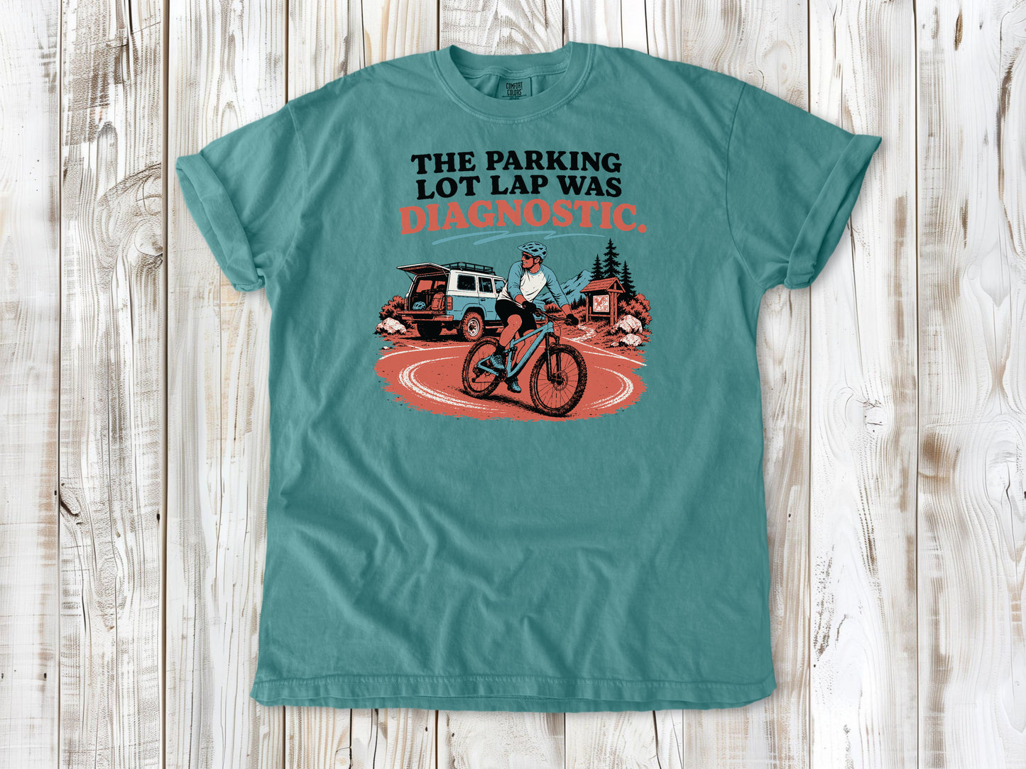 Mustard garment-dyed tee with The Parking Lot Lap Was Diagnostic mountain biking graphic.
