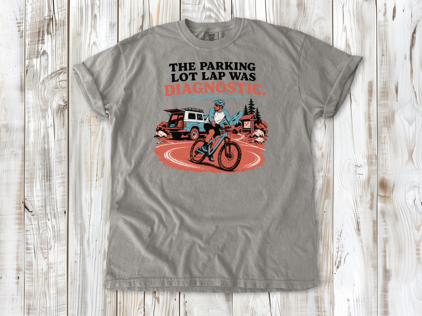 Khaki garment-dyed tee with The Parking Lot Lap Was Diagnostic mountain biking graphic.