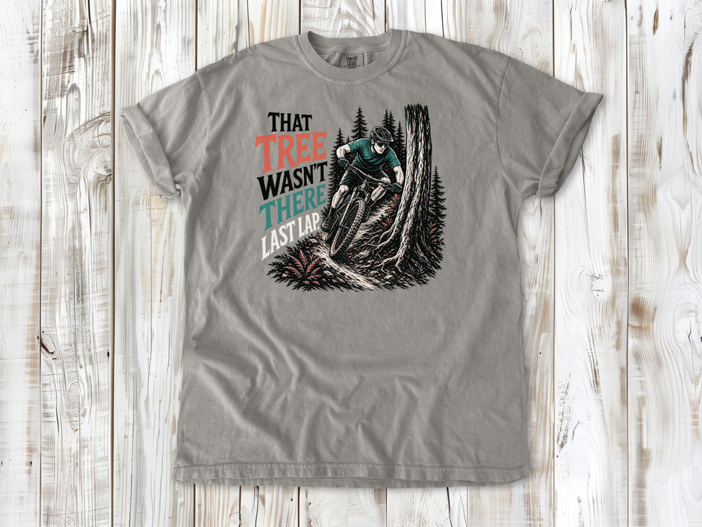 Khaki garment-dyed tee with That Tree Wasn't There Last Lap mountain bike trail graphic.
