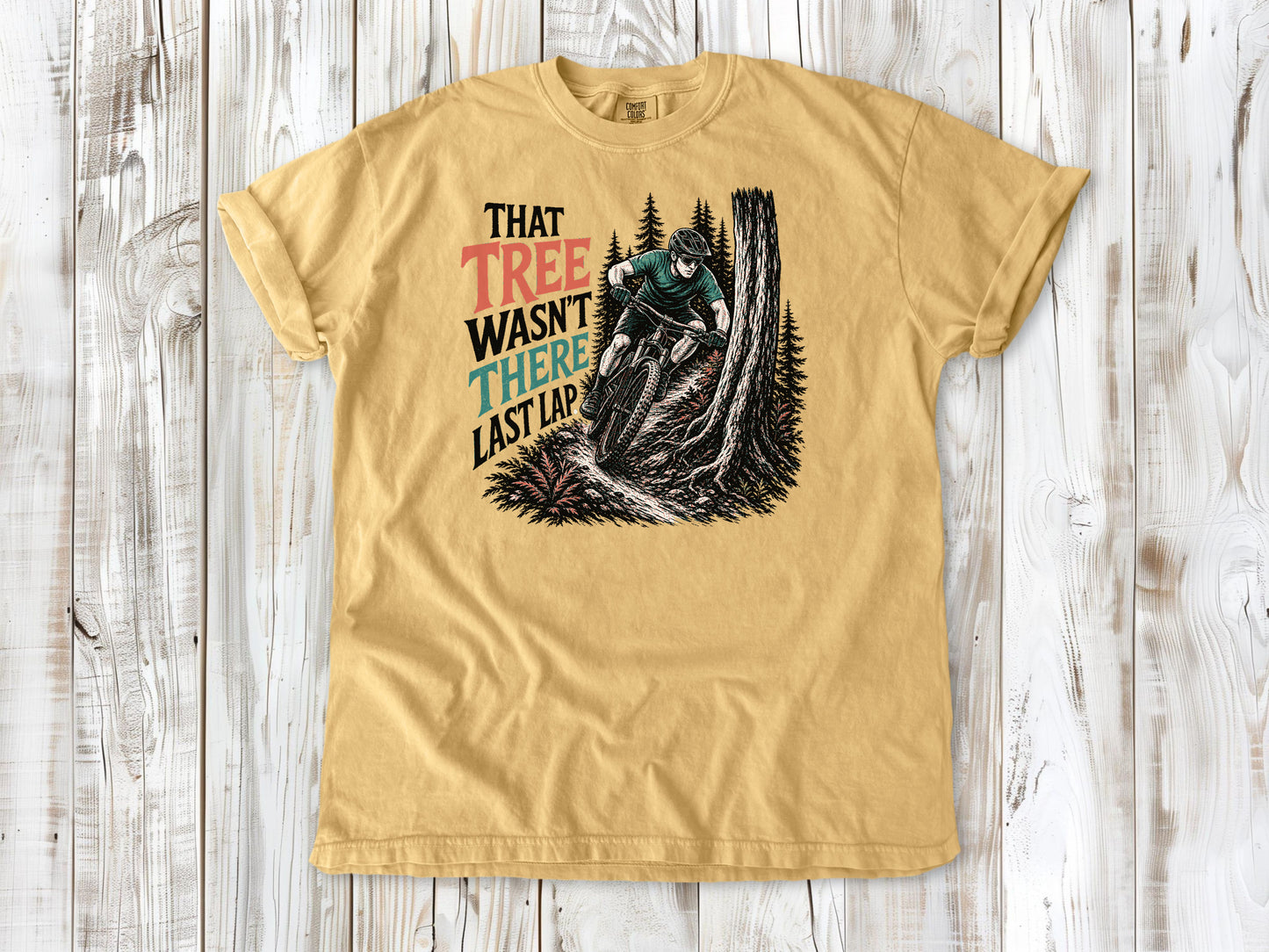 Burnt Orange garment-dyed tee with That Tree Wasn't There Last Lap mountain bike trail graphic.