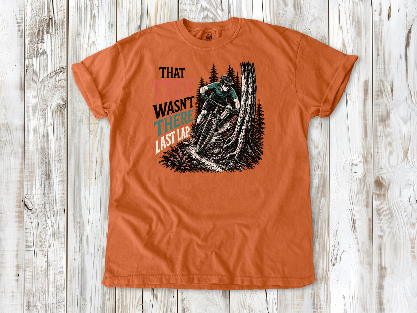 Seafoam garment-dyed tee with That Tree Wasn't There Last Lap mountain bike trail graphic.