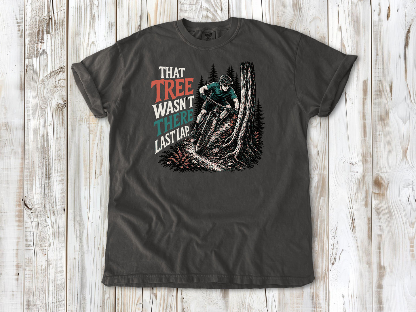 Ivory garment-dyed tee with That Tree Wasn't There Last Lap mountain bike trail graphic.