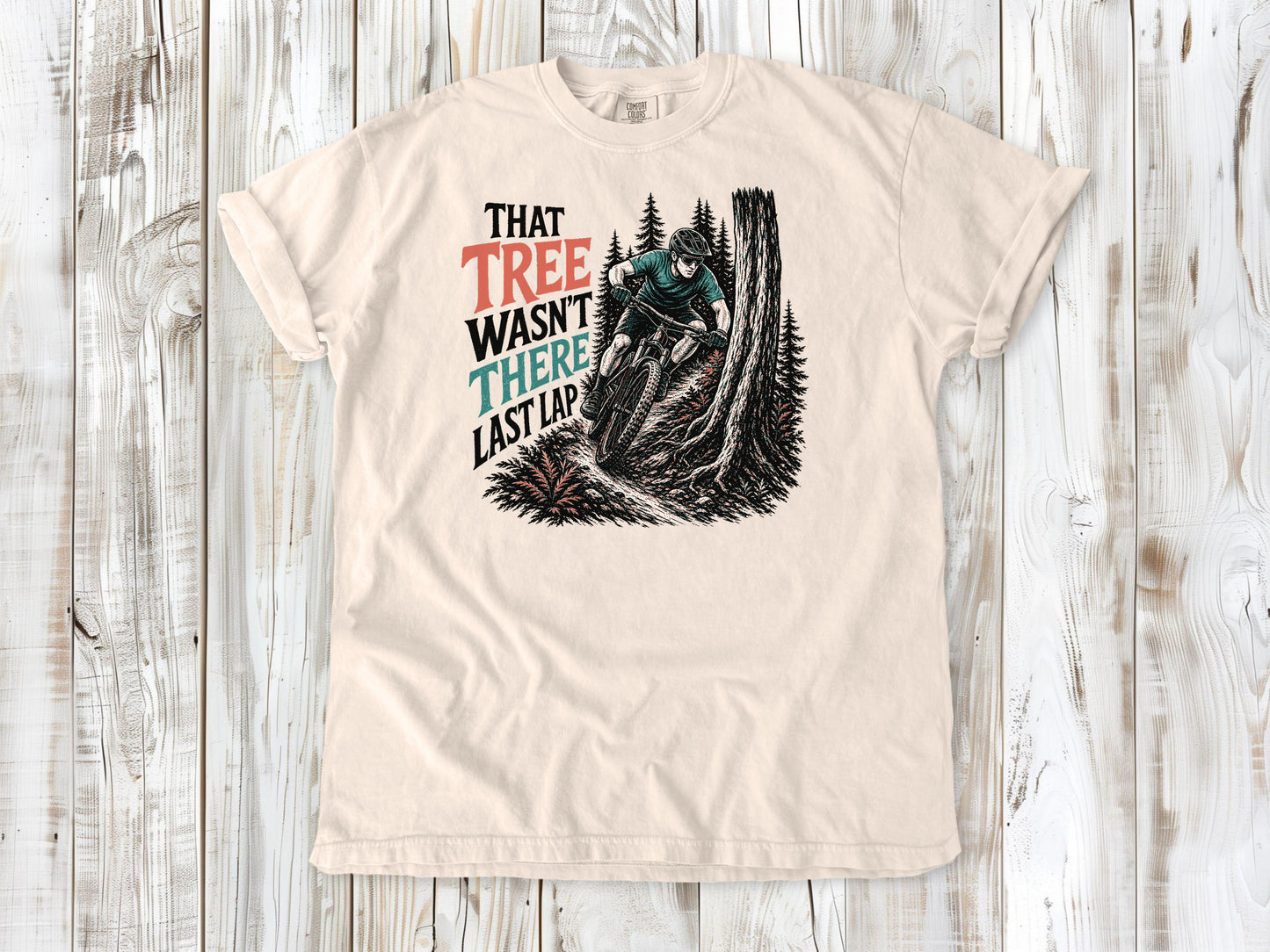 Butter garment-dyed tee with That Tree Wasn't There Last Lap mountain bike trail graphic.
