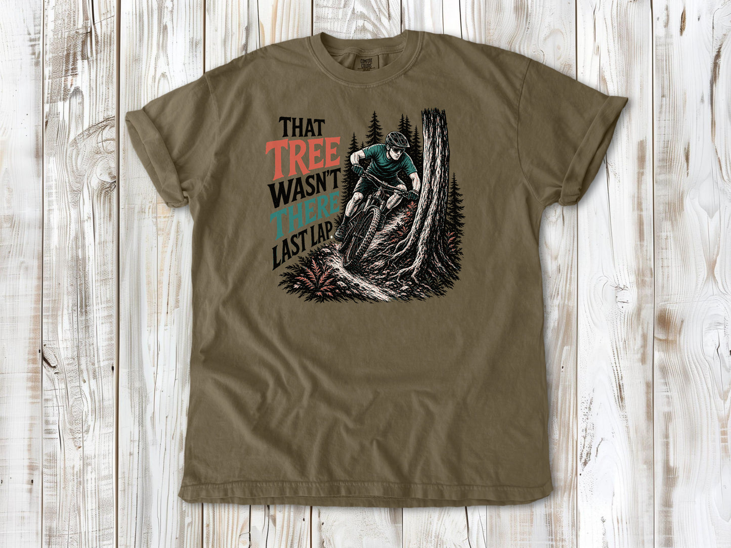 Graphite garment-dyed tee with That Tree Wasn't There Last Lap mountain bike trail graphic.