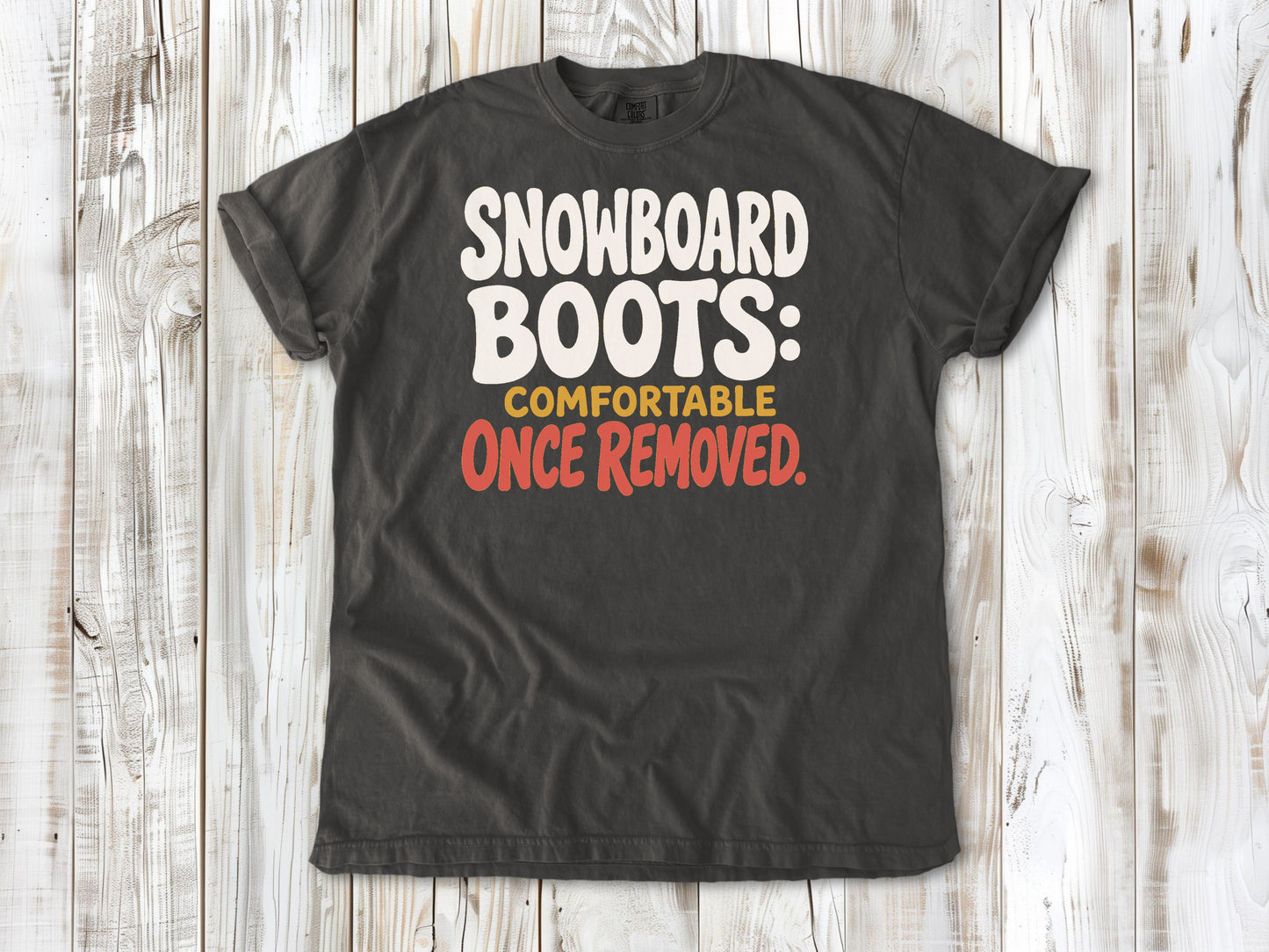 Ivory garment-dyed tee with Snowboard Boots Comfortable Once Removed graphic.
