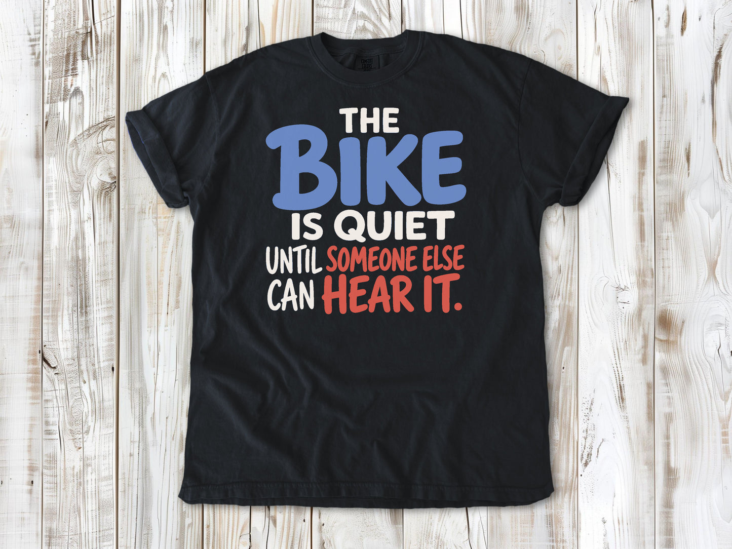 Washed Denim garment-dyed tee with The Bike Is Quiet Until Someone Else Can Hear It cycling graphic.