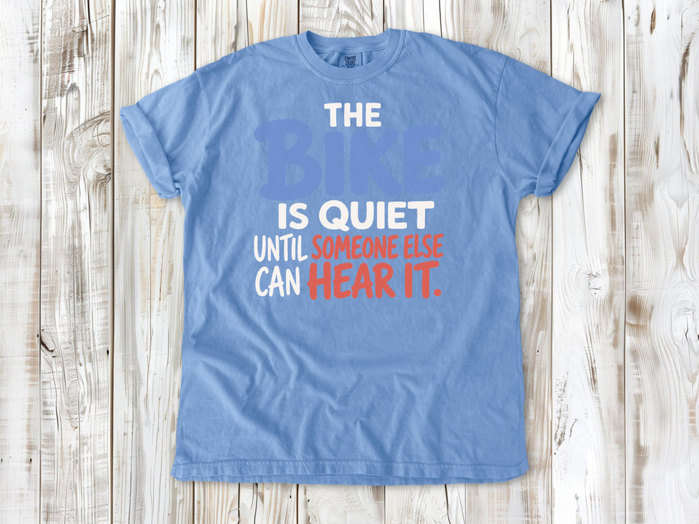 Pepper garment-dyed tee with The Bike Is Quiet Until Someone Else Can Hear It cycling graphic.