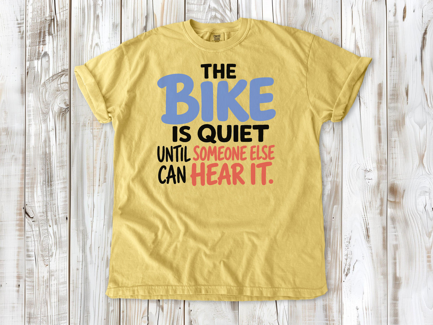 Grey garment-dyed tee with The Bike Is Quiet Until Someone Else Can Hear It cycling graphic.