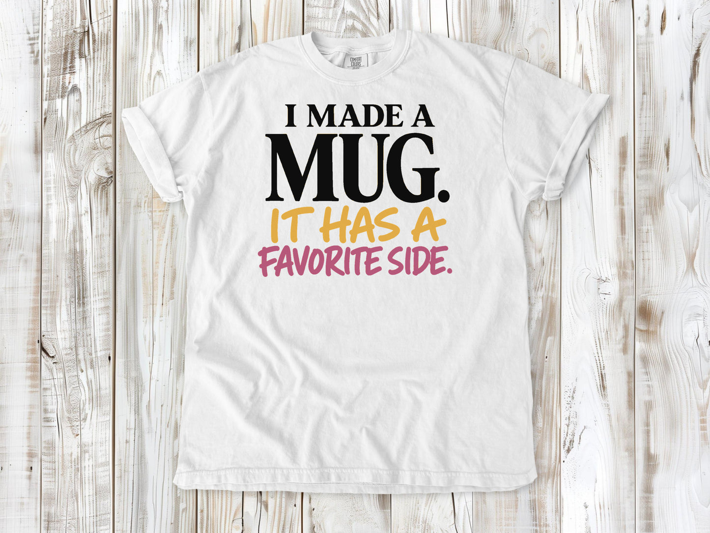 White garment-dyed tee with I Made a Mug It Has a Favorite Side pottery graphic.