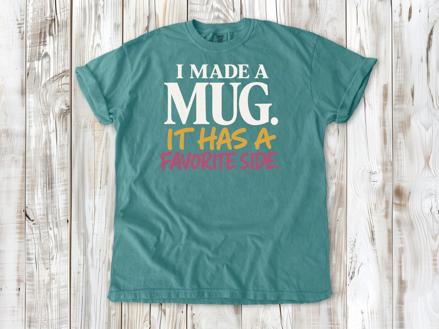 Mustard garment-dyed tee with I Made a Mug It Has a Favorite Side pottery graphic.
