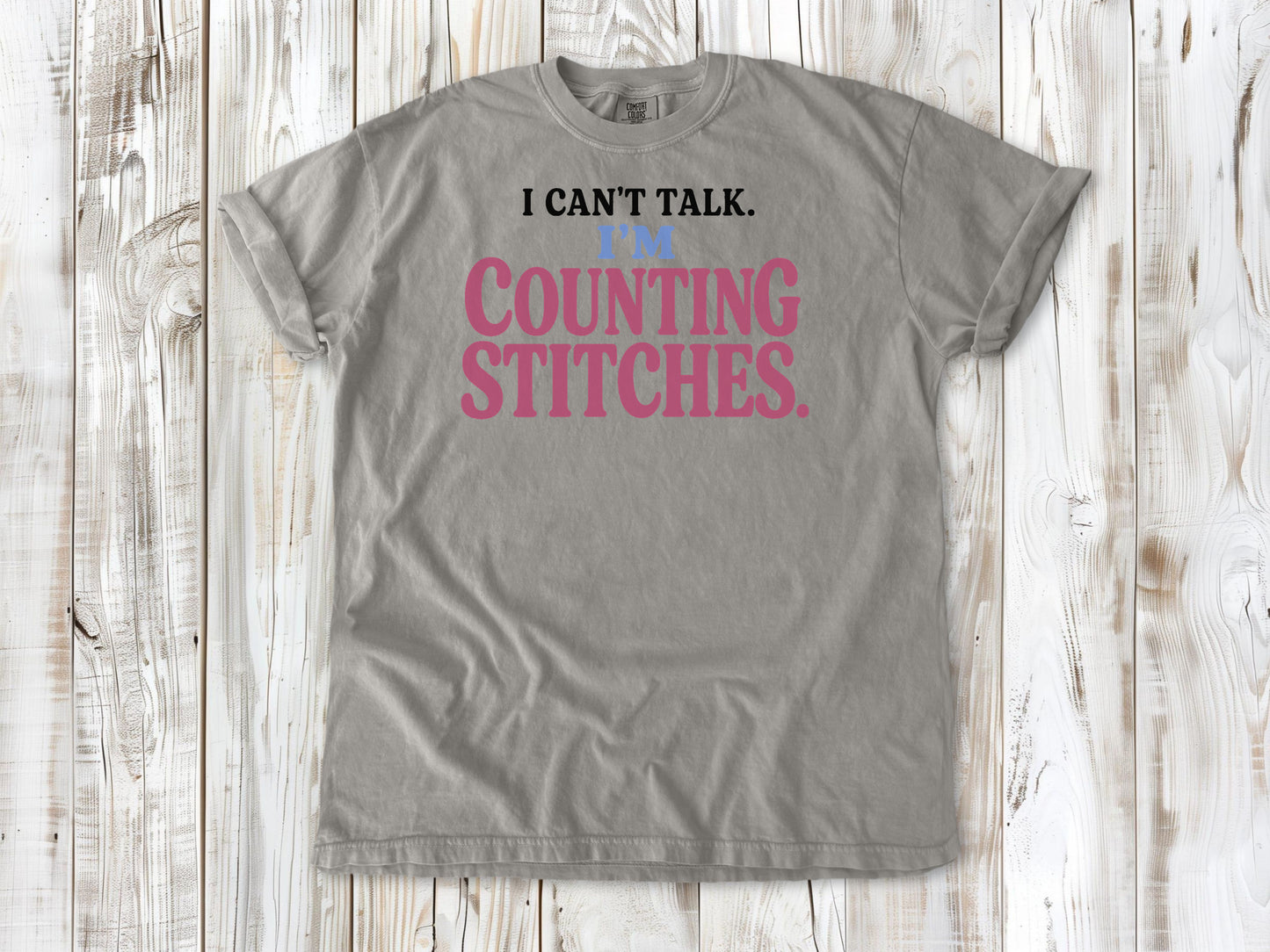 Khaki garment-dyed tee with I Can't Talk I'm Counting Stitches knitting and crochet graphic.