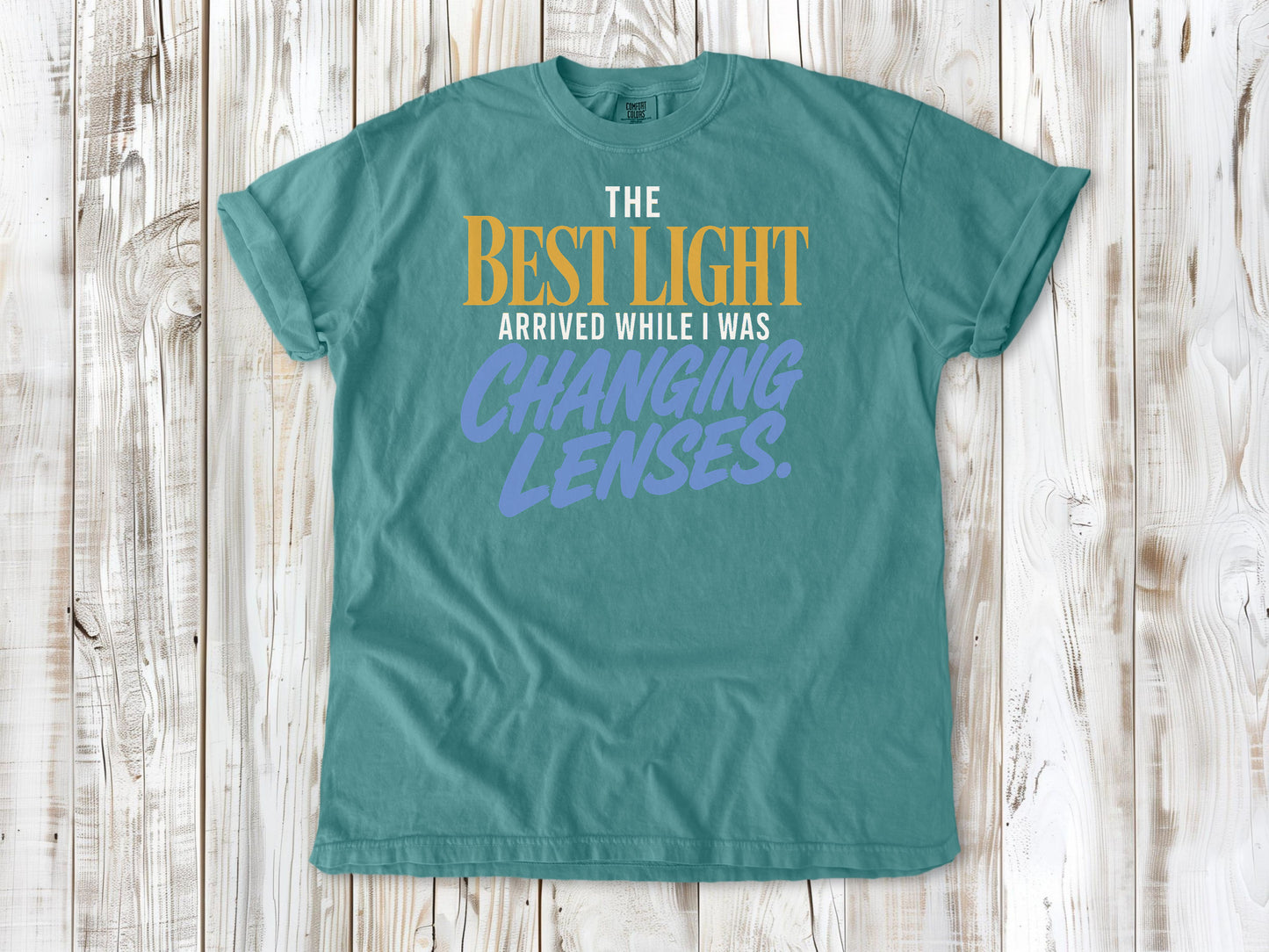 Mustard garment-dyed tee with The Best Light Arrived While I Was Changing Lenses photography graphic.