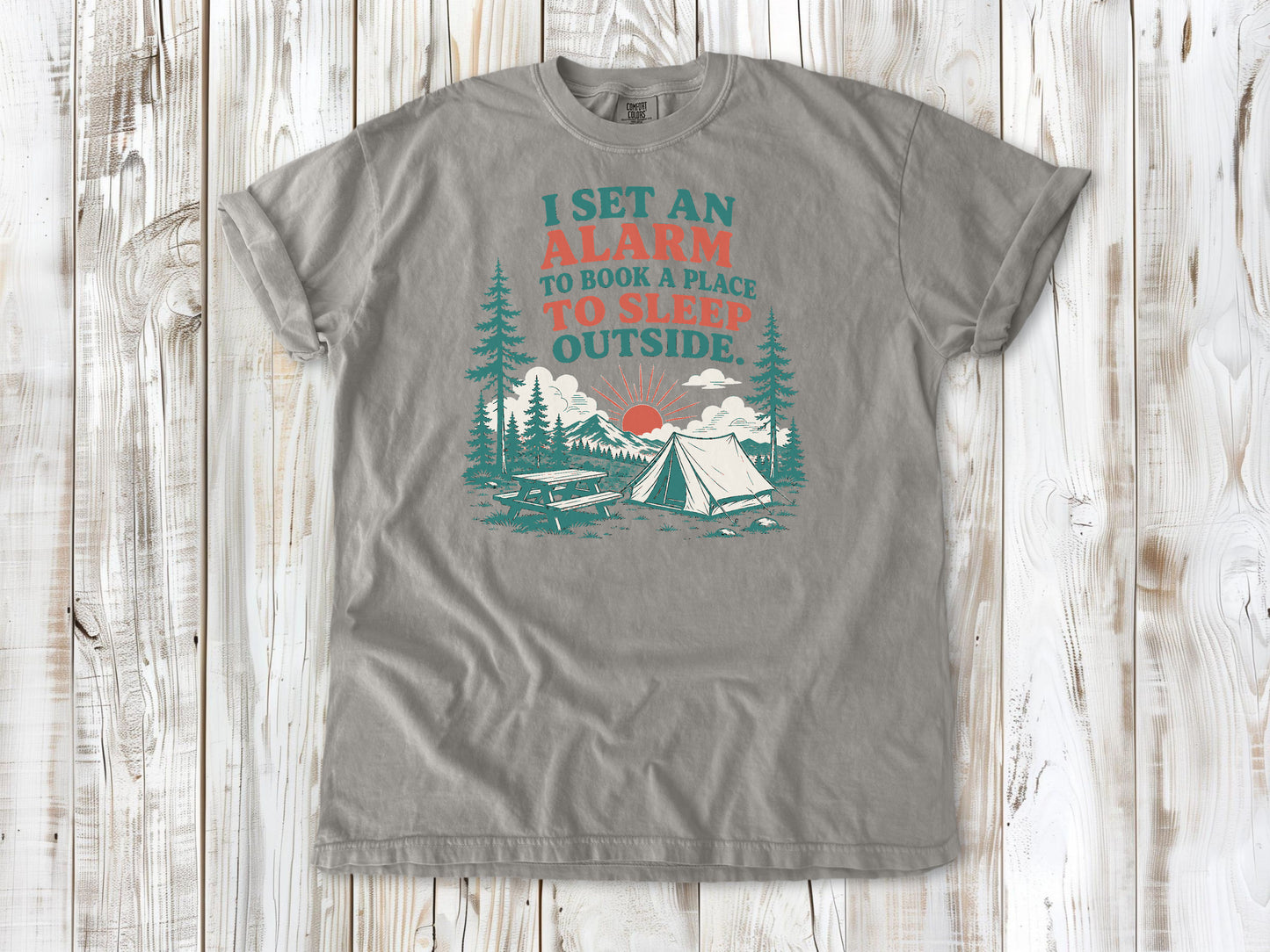 Grey garment-dyed tee with I Set an Alarm to Book a Place to Sleep Outside camping graphic.