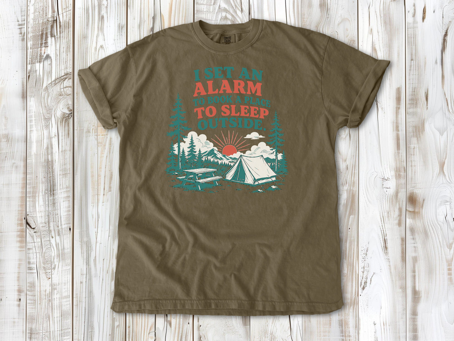 Khaki garment-dyed tee with I Set an Alarm to Book a Place to Sleep Outside camping graphic.
