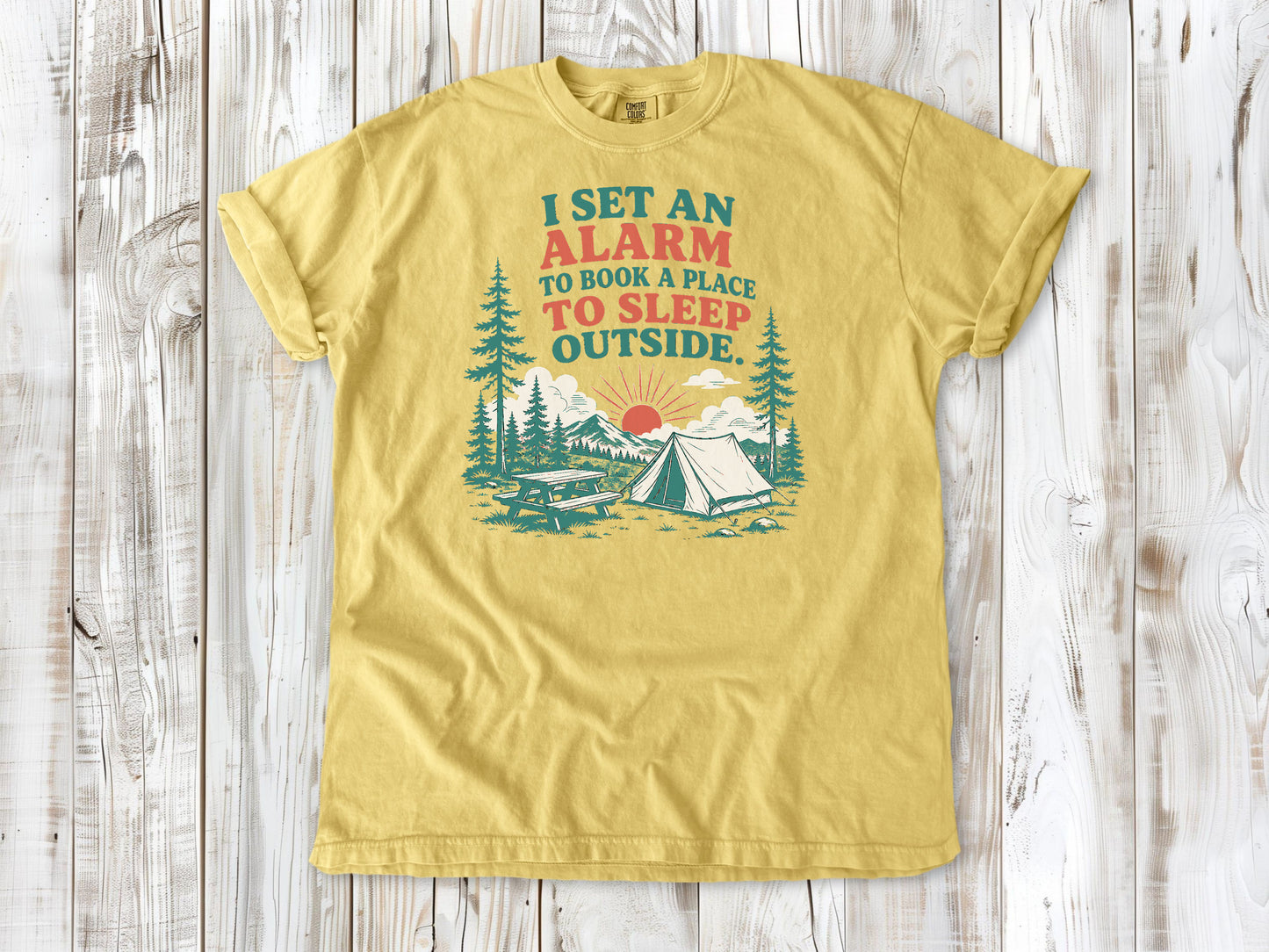 Butter garment-dyed tee with I Set an Alarm to Book a Place to Sleep Outside camping graphic.