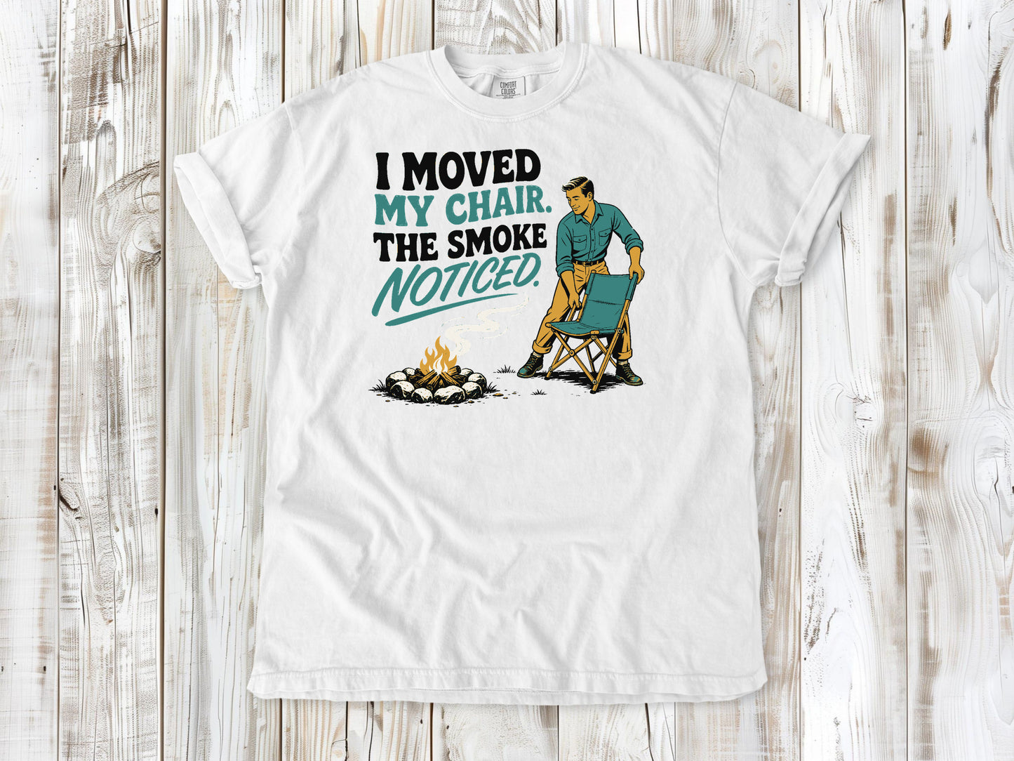 White garment-dyed tee with I Moved My Chair The Smoke Noticed campfire graphic.