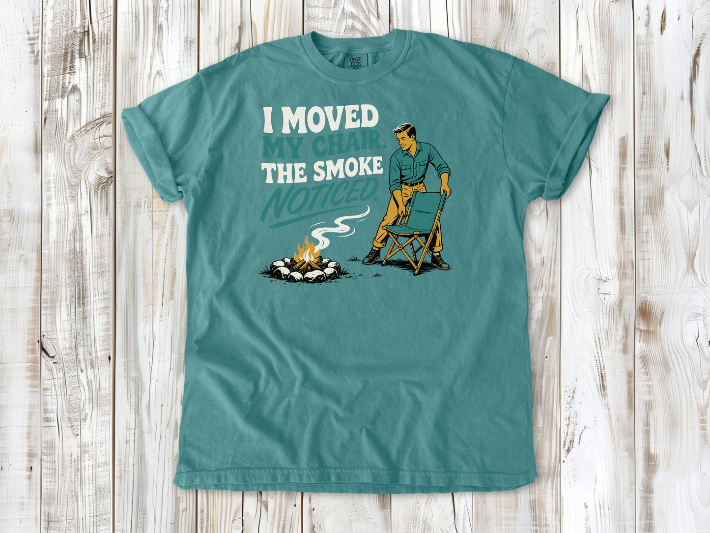 Mustard garment-dyed tee with I Moved My Chair The Smoke Noticed campfire graphic.