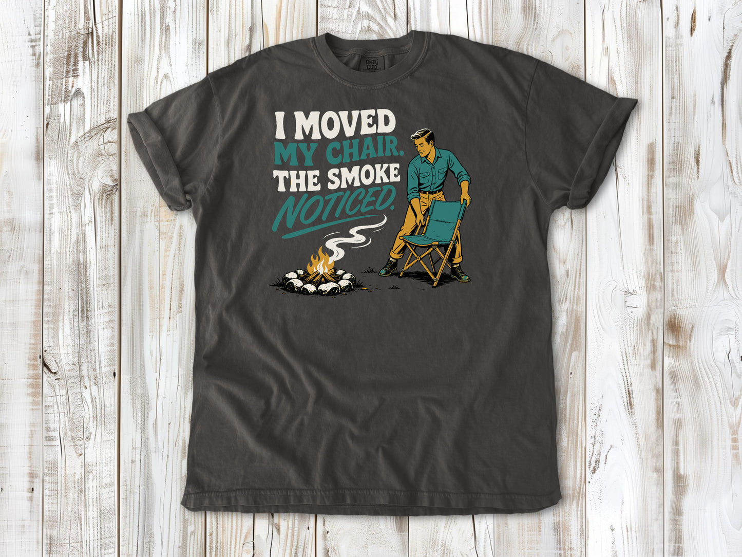 Ivory garment-dyed tee with I Moved My Chair The Smoke Noticed campfire graphic.