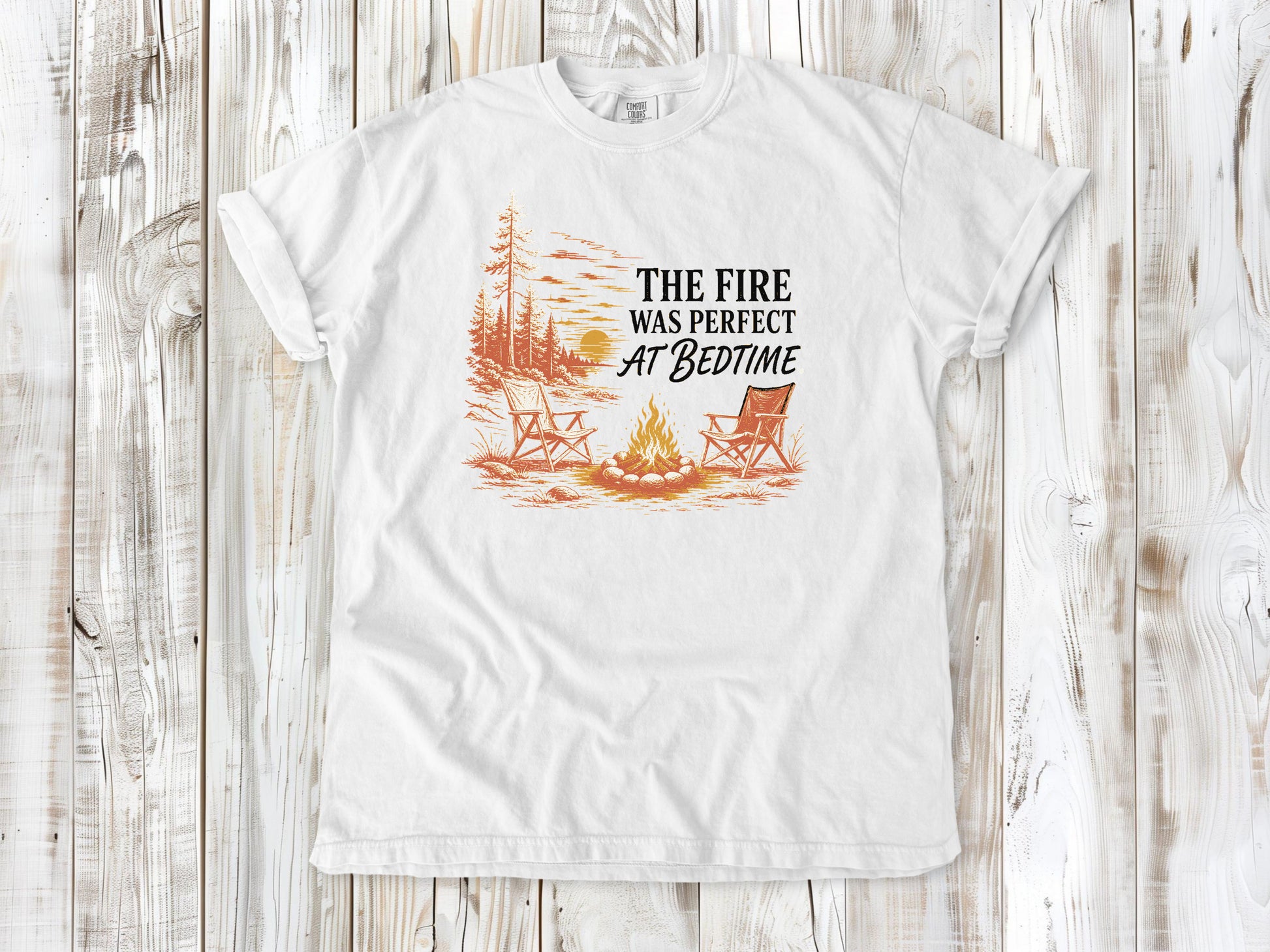 White garment-dyed tee with The Fire Was Perfect at Bedtime campfire graphic.