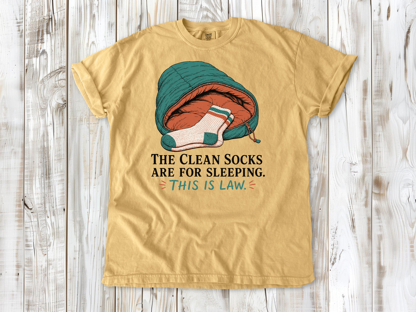 Burnt Orange garment-dyed tee with The Clean Socks Are for Sleeping This Is Law camping graphic.