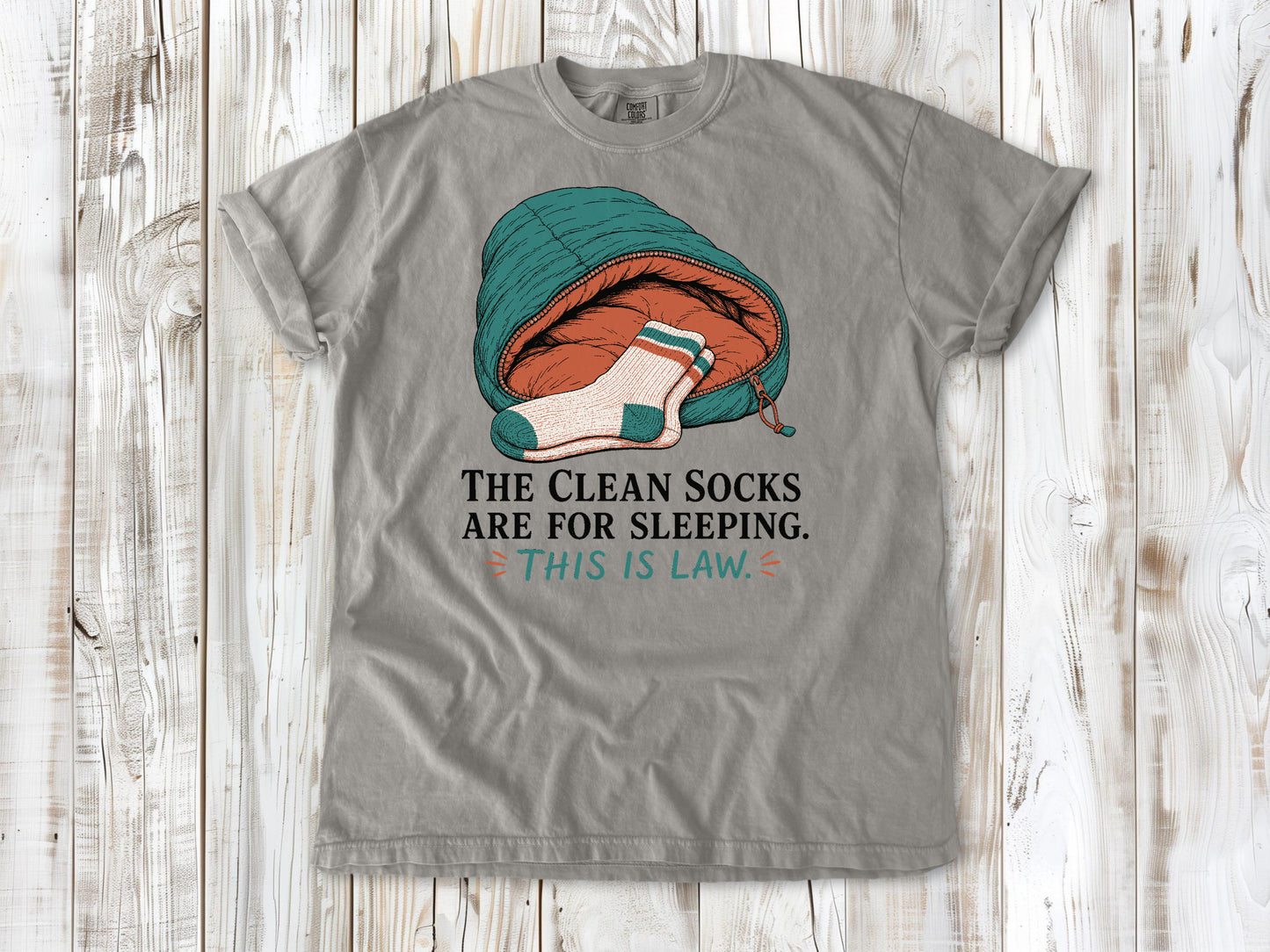 Khaki garment-dyed tee with The Clean Socks Are for Sleeping This Is Law camping graphic.