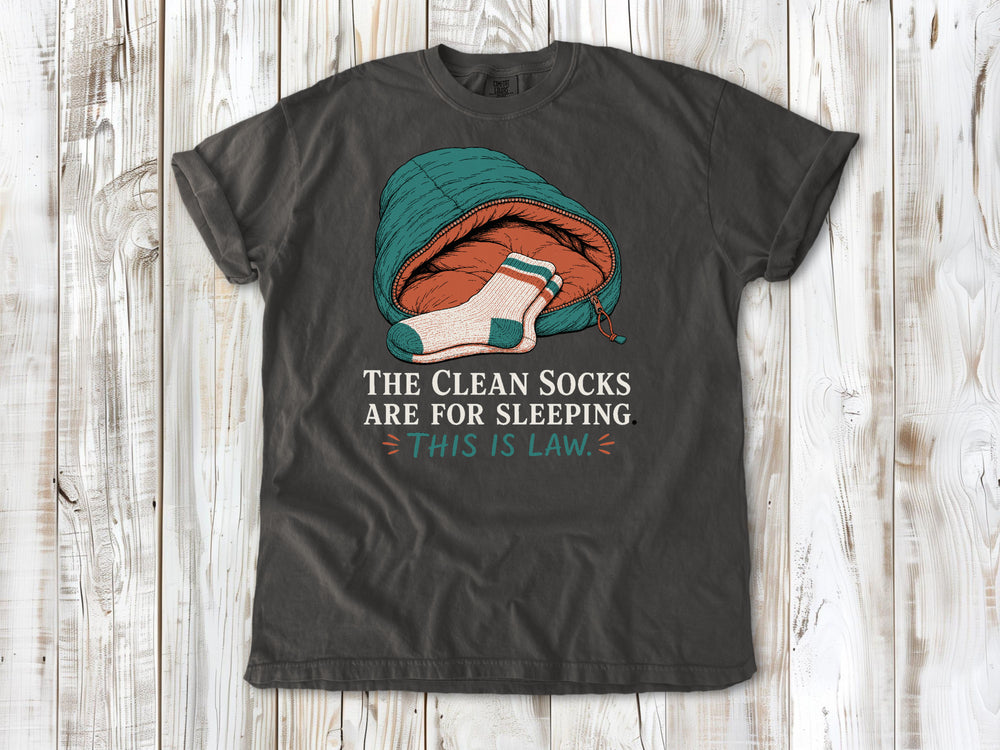 Ivory garment-dyed tee with The Clean Socks Are for Sleeping This Is Law camping graphic.
