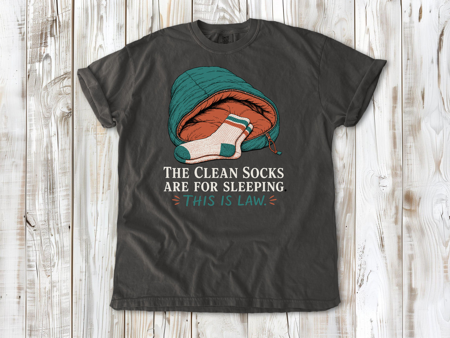 Ivory garment-dyed tee with The Clean Socks Are for Sleeping This Is Law camping graphic.