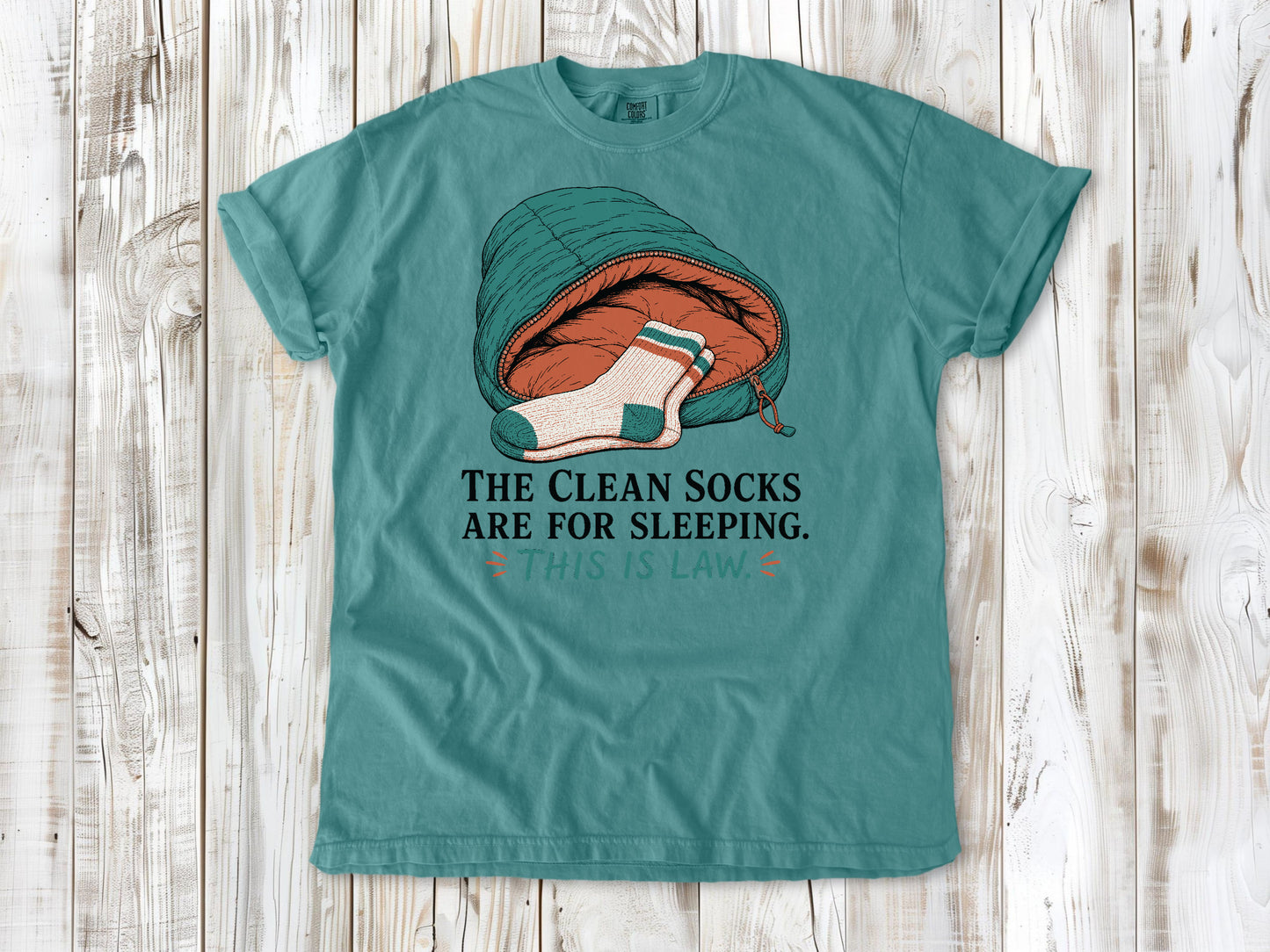 Mustard garment-dyed tee with The Clean Socks Are for Sleeping This Is Law camping graphic.