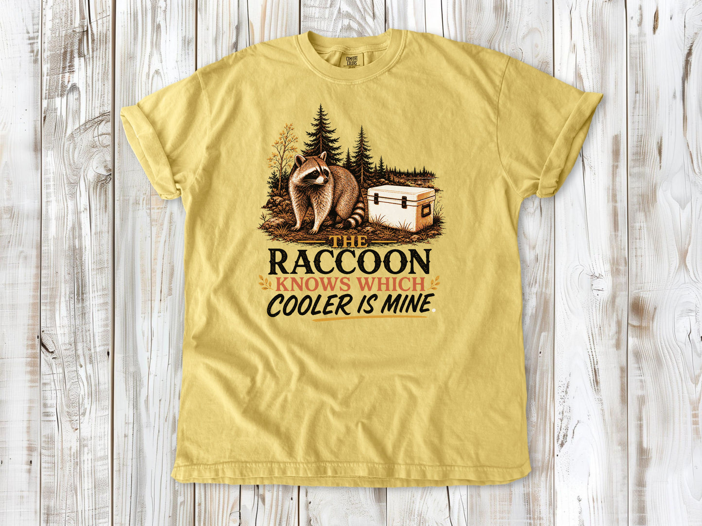 Grey garment-dyed tee with The Raccoon Knows Which Cooler Is Mine camping graphic.