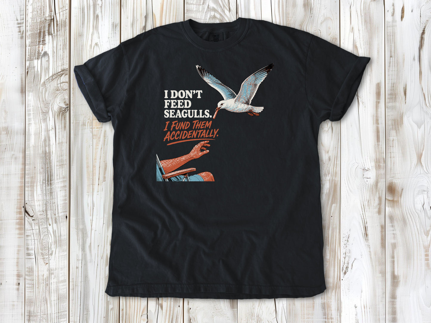 Washed Denim garment-dyed tee with I Don't Feed Seagulls I Fund Them Accidentally beach graphic.