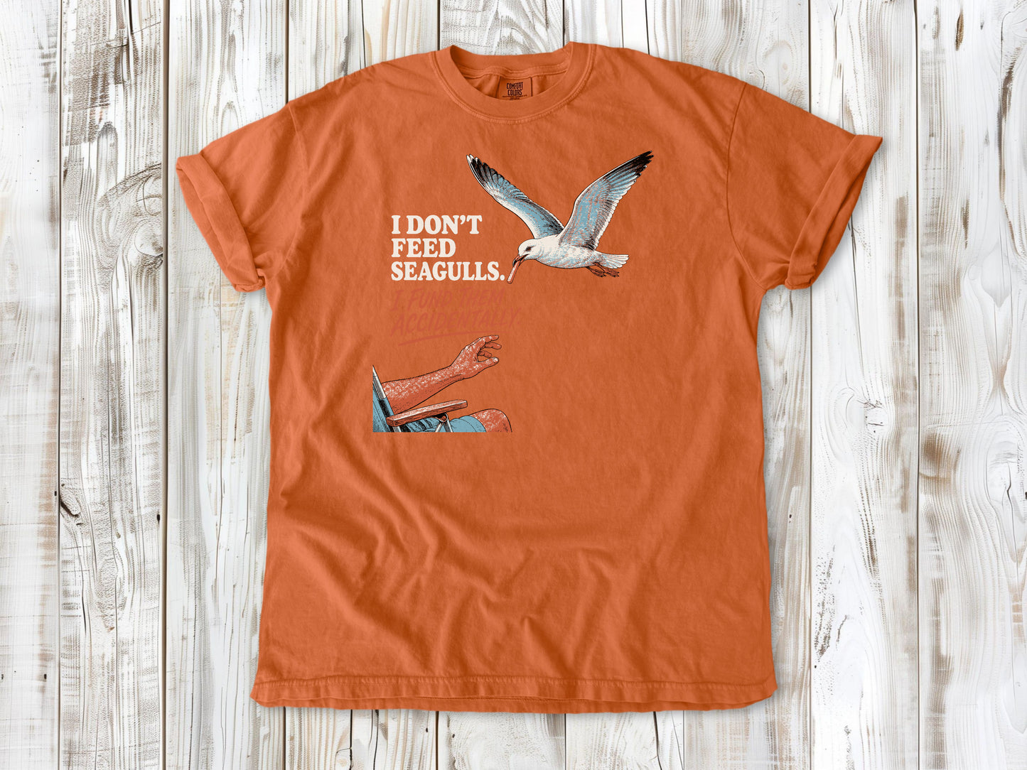 Seafoam garment-dyed tee with I Don't Feed Seagulls I Fund Them Accidentally beach graphic.