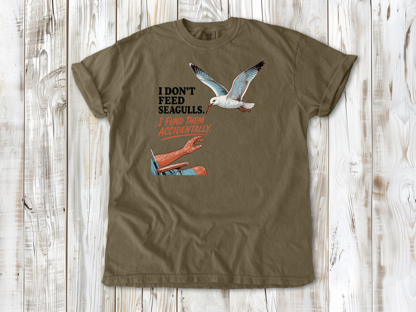 Graphite garment-dyed tee with I Don't Feed Seagulls I Fund Them Accidentally beach graphic.
