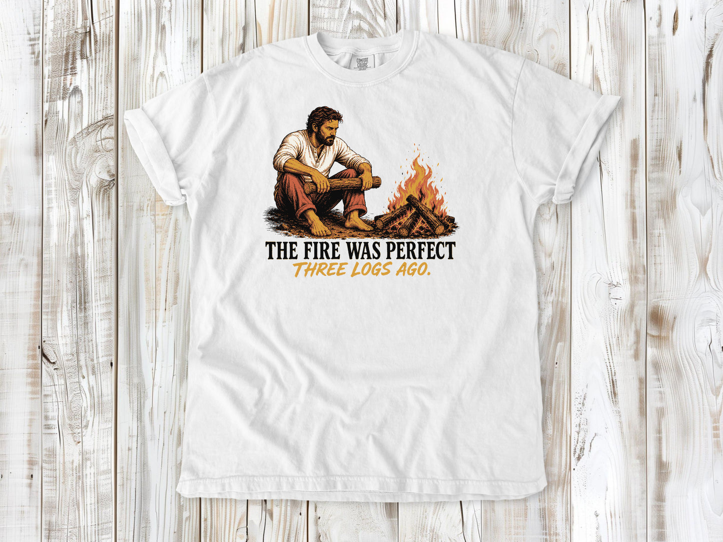White garment-dyed tee with The Fire Was Perfect Three Logs Ago beach bonfire graphic.