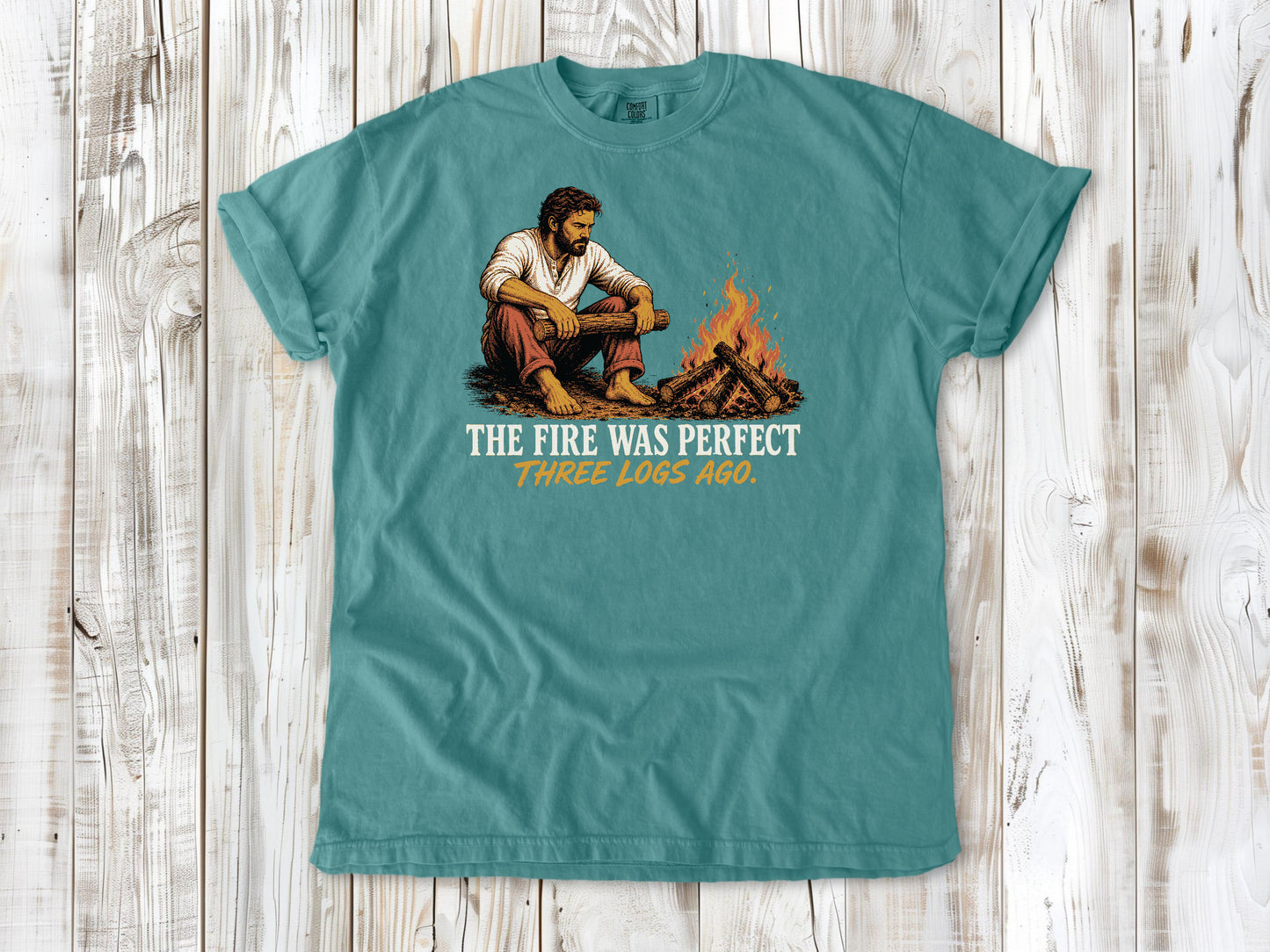 Mustard garment-dyed tee with The Fire Was Perfect Three Logs Ago beach bonfire graphic.