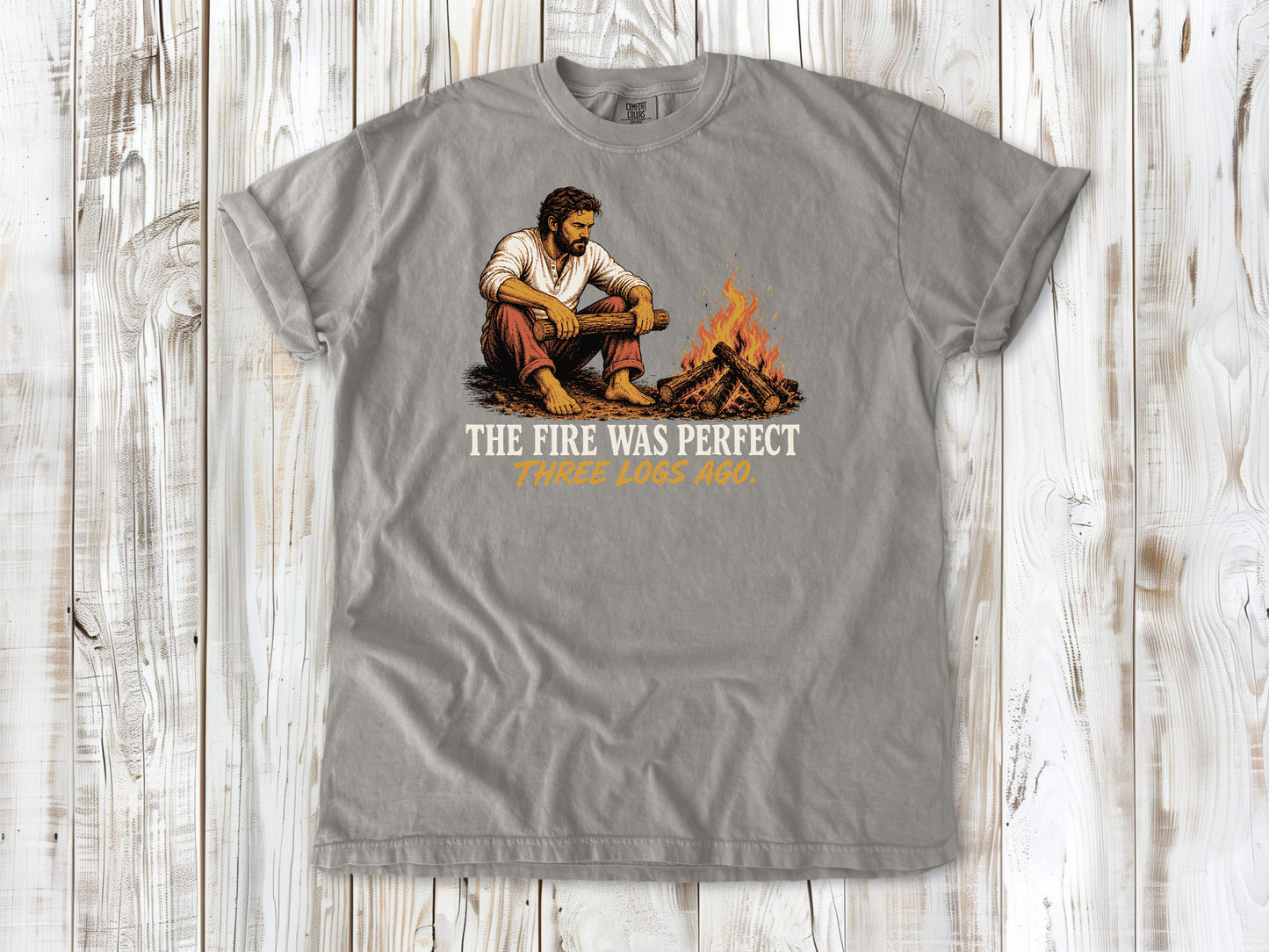 Khaki garment-dyed tee with The Fire Was Perfect Three Logs Ago beach bonfire graphic.