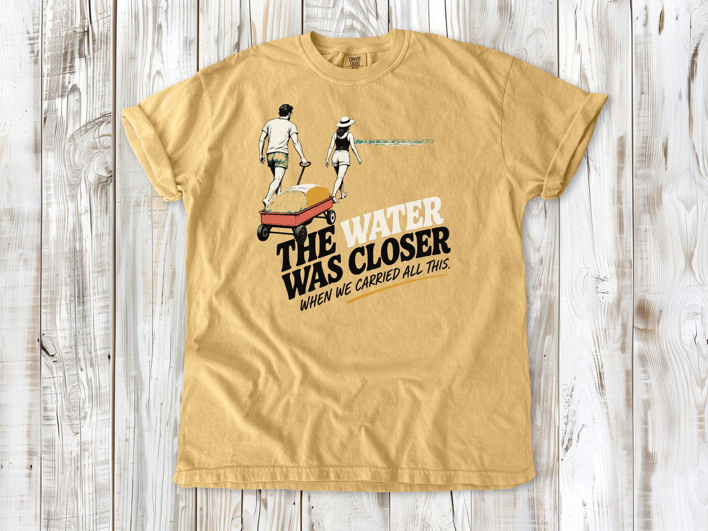 Burnt Orange garment-dyed tee with The Water Was Closer When We Carried All This beach graphic.
