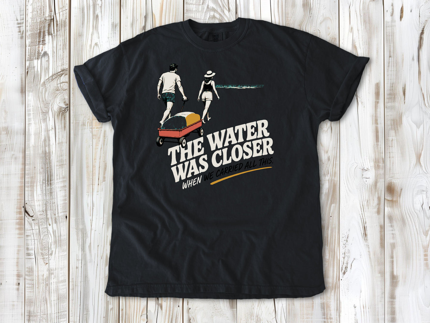 Washed Denim garment-dyed tee with The Water Was Closer When We Carried All This beach graphic.