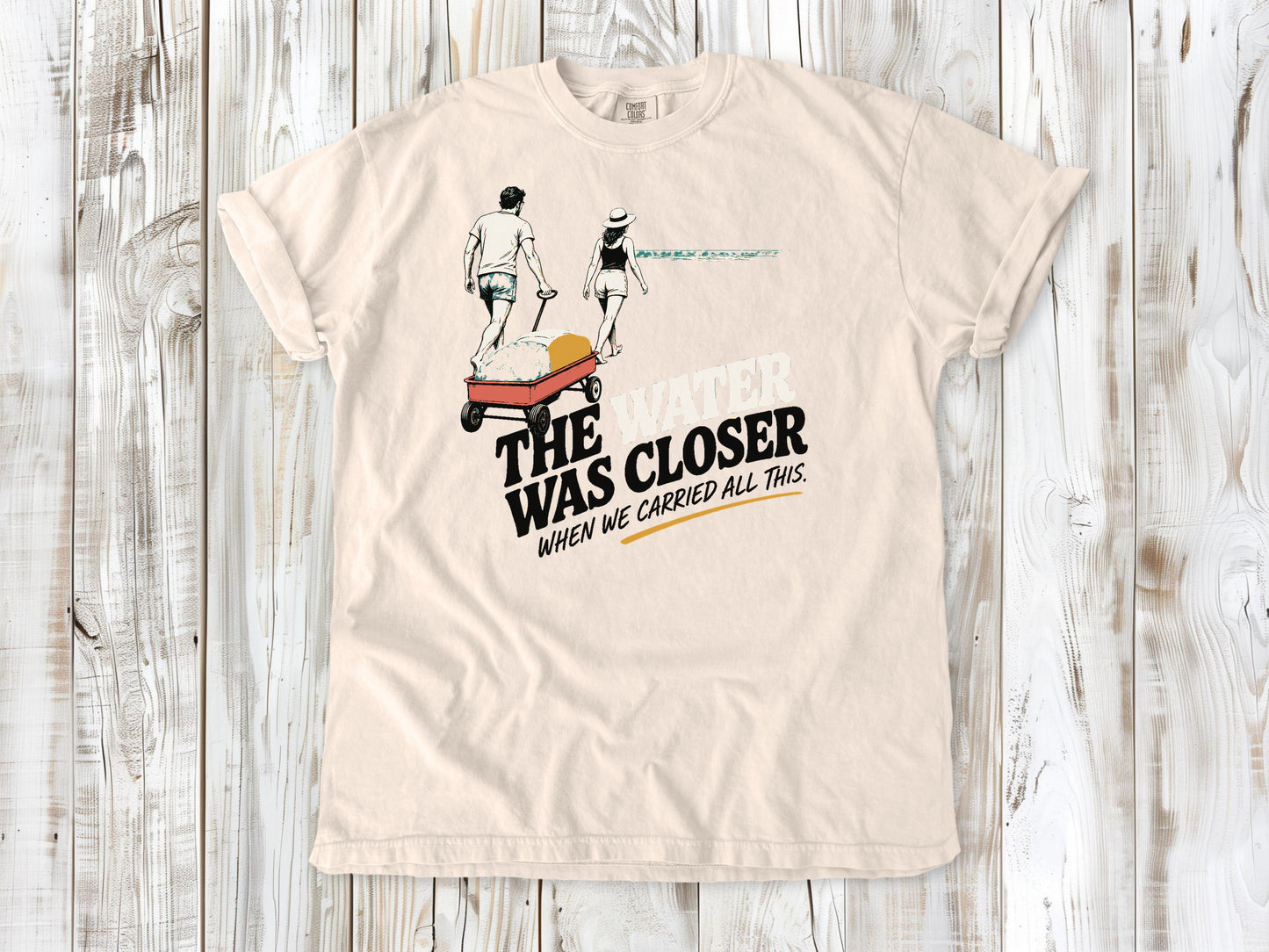 Butter garment-dyed tee with The Water Was Closer When We Carried All This beach graphic.