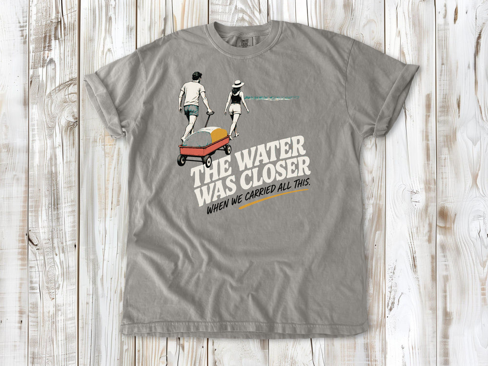 Khaki garment-dyed tee with The Water Was Closer When We Carried All This beach graphic.